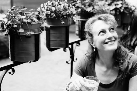 Portrait of beautiful 40 years old woman sitting in outdoor cafeの写真素材