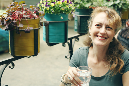 Portrait of beautiful 40 years old woman sitting in outdoor cafeの写真素材