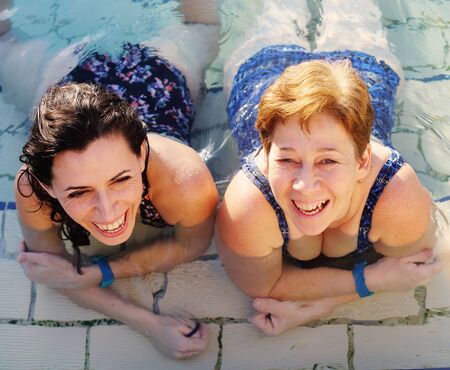 Portrait of two 40 years old women in swimming-poolの写真素材