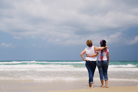 Outdoor portrait of two women standing on the beachの写真素材