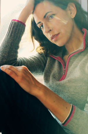 Portrait of beautiful woman looking throught the windowの写真素材