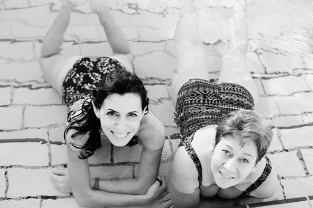Portrait of two 40 years old women in swimming-poolの写真素材