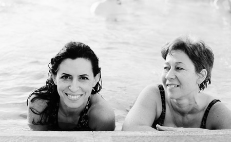 Portrait of two 40 years old women in swimming-poolの写真素材