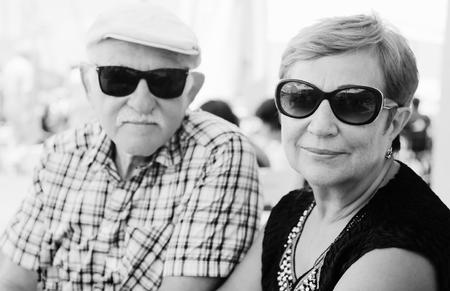 Portrait of senior couple sitting in summer cafeの写真素材
