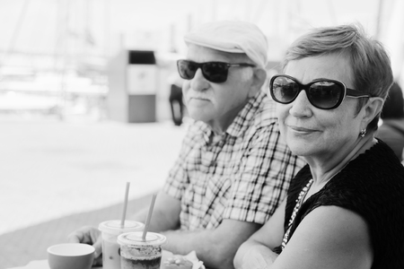 Portrait of senior couple sitting in summer cafeの写真素材