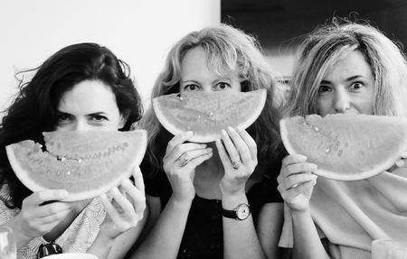Portrait of three 40 years old woman eating watermelonの写真素材