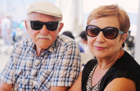 Portrait of senior couple sitting in summer cafeの写真素材