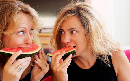 Portrait of two 40 years old woman eating watermelonの写真素材
