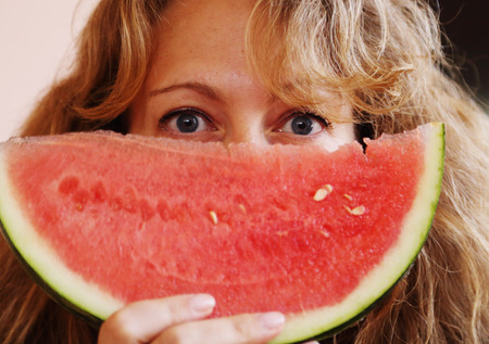 Portrait of 40 years old woman eating watermelonの写真素材