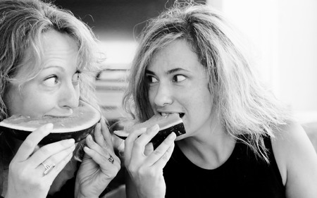 Portrait of two 40 years old woman eating watermelonの写真素材