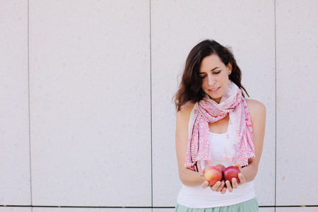 Beautiful woman is holding with freshly organic red applesの写真素材
