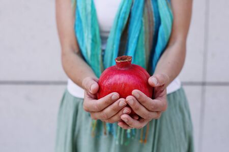 Womans hands with freshly organic red pomegranateの写真素材