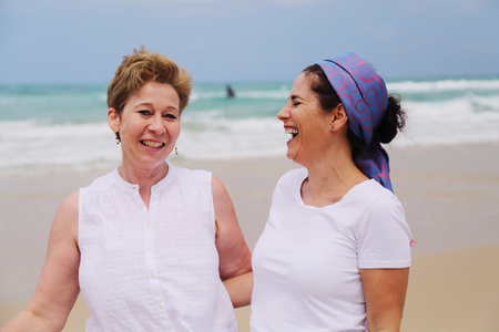 Outdoor portrait of two women standing on the beachの写真素材