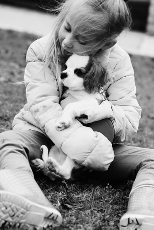 7 year old girl is walking with a puppy in the parkの写真素材