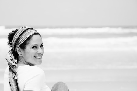 Portrait of three beautiful 40 years old woman sitting on seasideの写真素材