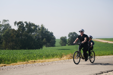 father and son ride a tandem bikeの写真素材