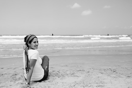 Portrait of three beautiful 40 years old woman sitting on seasideの写真素材
