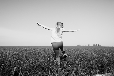 Cute girl jumping in the fieldの写真素材