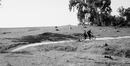 father with autistic 10 years old son ride a tandem bikeの写真素材
