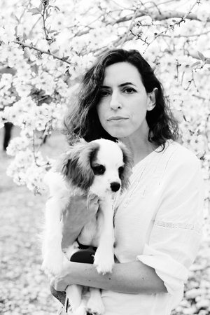 40 years old woman is walking with a puppy in the parkの写真素材