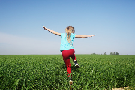 Cute girl jumping in the fieldの写真素材