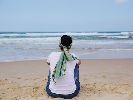 Portrait of three beautiful 40 years old woman sitting on seasideの写真素材