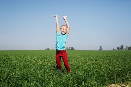 Cute girl jumping in the fieldの写真素材