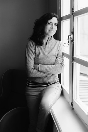 Indoor portrait of beautiful 45 years old woman next to the windowの写真素材