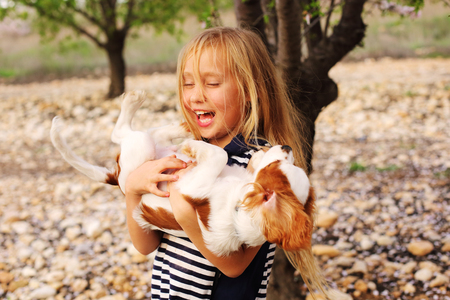 7 year old girl is walking with a puppy in the parkの写真素材
