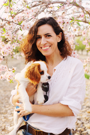 40 years old woman is walking with a puppy in the parkの写真素材