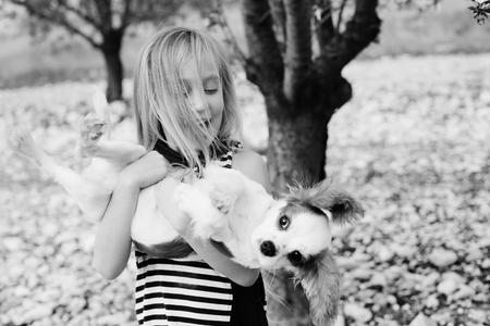 7 year old girl is walking with a puppy in the parkの写真素材