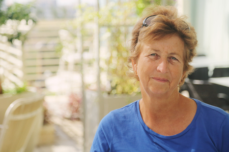 close up portrait of senior woman sitting in outdoor summer cafe の写真素材
