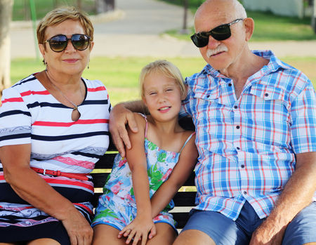 Grandparents And Granddaughter Enjoying Day In Parkの写真素材