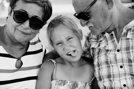 Grandparents And Granddaughter Enjoying Day In Parkの写真素材