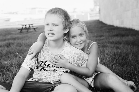 Portrait of happy 7 years old girl with her 10 years old autistic brother outdoorsの写真素材