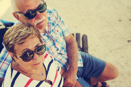 Mature couple resting in park on summer dayの写真素材