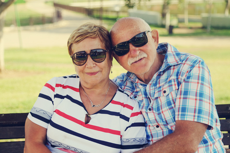 Mature couple resting in park on summer dayの写真素材