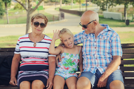 Grandparents And Granddaughter Enjoying Day In Parkの写真素材