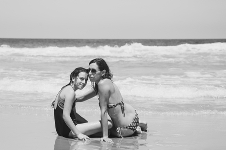 Mother and daughter having fun to spend time together on the beach at sunsetの写真素材