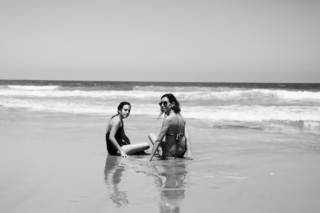 Mother and daughter having fun to spend time together on the beach at sunsetの写真素材