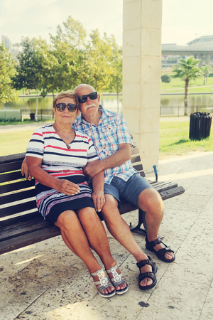 Mature couple resting in park on summer dayの写真素材