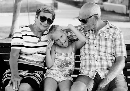 Grandparents And Granddaughter Enjoying Day In Parkの写真素材