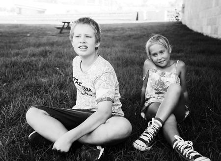 Portrait of happy 7 years old girl with her 10 years old autistic brother outdoorsの写真素材
