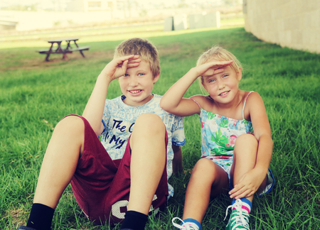 Portrait of happy 7 years old girl with her 10 years old autistic brother outdoorsの写真素材