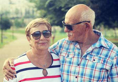 Mature couple resting in park on summer dayの写真素材