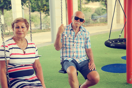 Mature couple resting in park on summer dayの写真素材