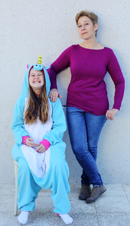 Mother with daughter in a unicorn costume. Strange family, teen problemsの写真素材