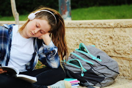 Portrait of tenage girl sitting outdoor with a bookの写真素材