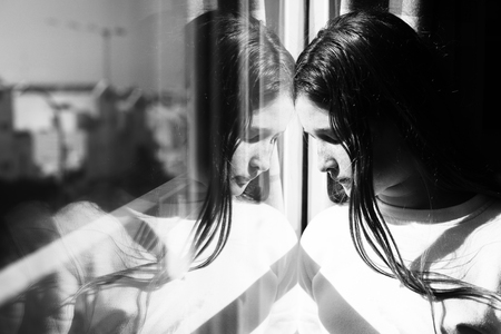 attractive sad teenage girl looking out of the window