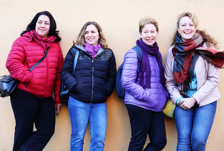 Women best friends smiling and walking at the city.  Outdoors lifestyle fashion portrait. Positive emotions.の写真素材